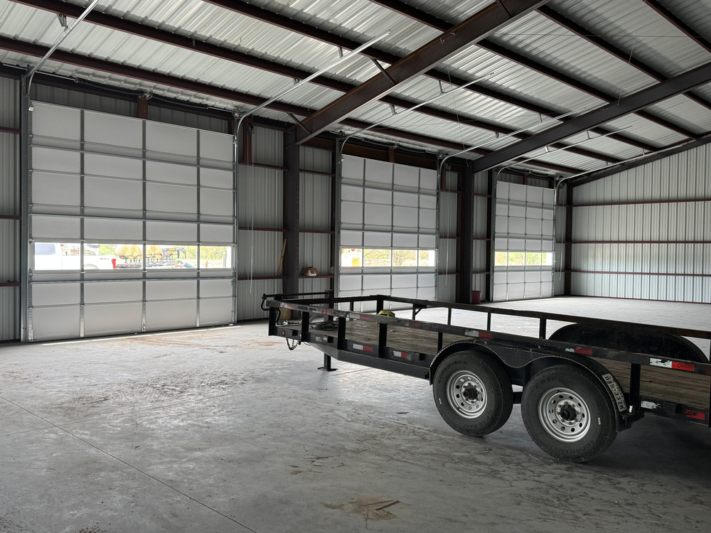 Multiple commercial sectional overhead doors installed inside a metal building