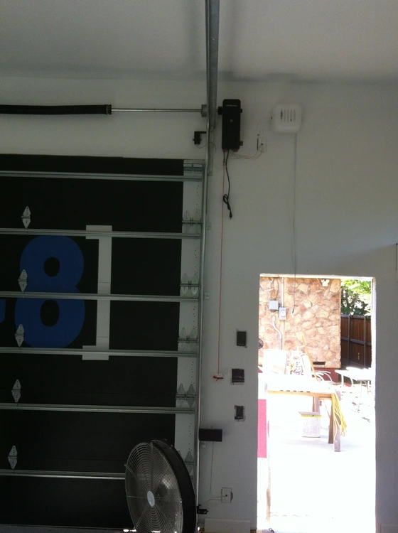 Residential sectional garage door with side-mounted opener, track, and operating hardware