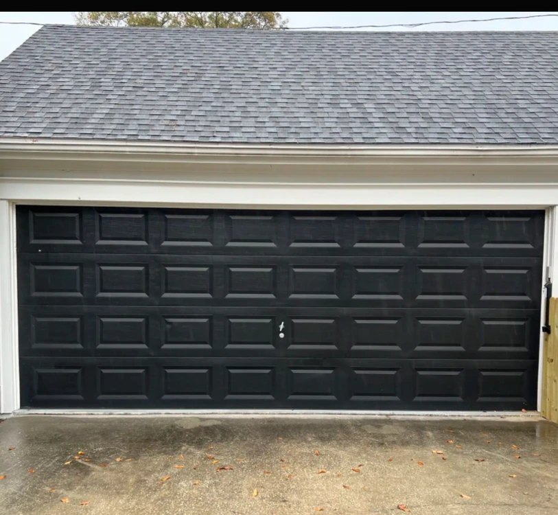 Black residential sectional garage door on a home